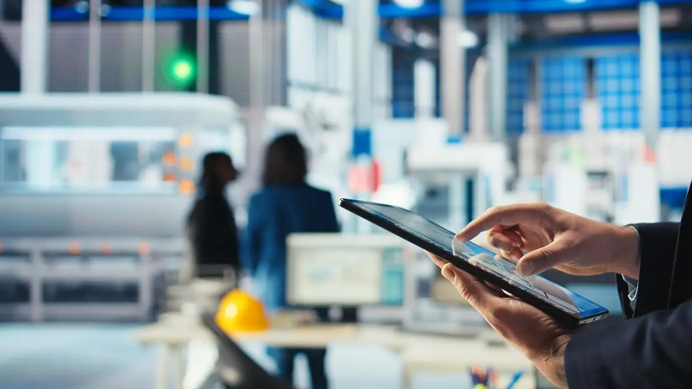 Un trabajador de una fábrica fotovoltaica utiliza software de seguimiento en una tableta para diagnosticar el sistema.